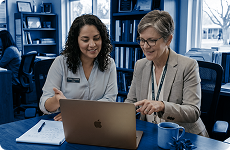 Two educators discussing about Pass while looking at the laptop screen